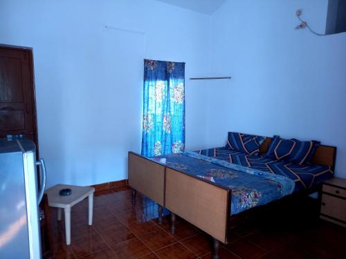 Habitación azul con cama con pared azul en Goa tour advisor & hospitality, en Candolim