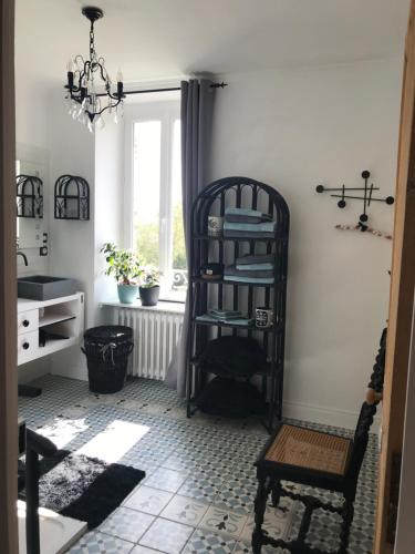 une chambre avec une étagère, une chaise et une fenêtre dans l'établissement Manoir de Lanveur, à Fouesnant