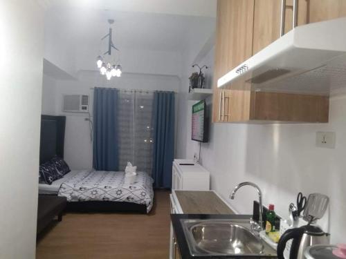 カガヤン・デ・オロにあるStudio Condo at The Loop Tower, Limketkai Dr, Cagayan de Oro Cityのキッチンの真ん中にベッドがある小さなアパート