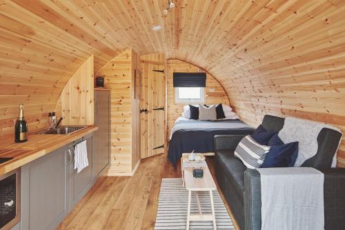 Hidden Orchard في تشيستر: غرفة مع سرير وأريكة في كابينة خشب