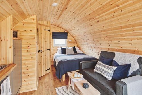 a room with a bed and a couch in a log cabin at Hidden Orchard in Chester