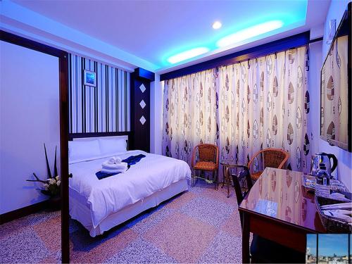 a bedroom with a bed and a desk and a table at 台東市安慶67套房館歡迎短租長租 in Taitung City
