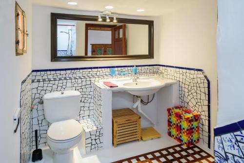 een badkamer met een wastafel, een toilet en een spiegel bij Lanzahost Finca Mojon in El Mojón