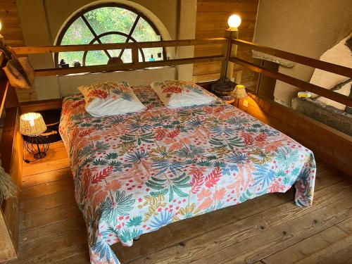 um quarto com uma cama com um edredão colorido em Gite 2 à 7 personnes proche Puy du Fou em Treize-Vents