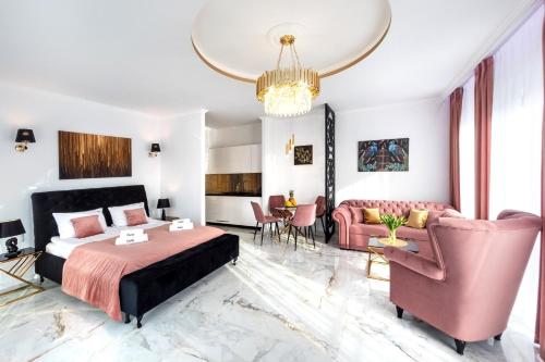 a bedroom with a king sized bed and pink furniture at Pokoje, Apartamenty, Domki nad Morzem Dune Resort Łeba in Łeba