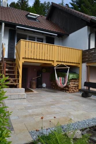 a house with a patio with a hammock hanging from it at Fichtenstüble in Todtmoos