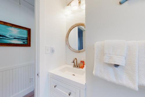 La salle de bains blanche est pourvue d'un lavabo et d'un miroir. dans l'établissement Salty Air, à Gulf Shores