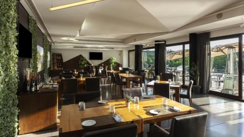 a restaurant with wooden tables and chairs and windows at Aqua Village, Health Resort in Oliveira do Hospital