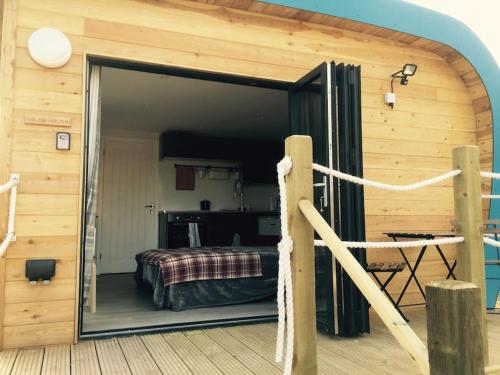 比尔Escape Pod in Devon, 5 mins from beach + parking的一间卧室设有一张床和一个玻璃门廊
