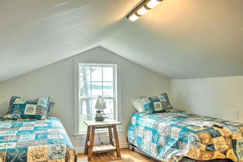 Un dormitorio abuhardillado con dos camas y una ventana. en Paradise Point Pamlico River Home with Dock and View, en Aurora