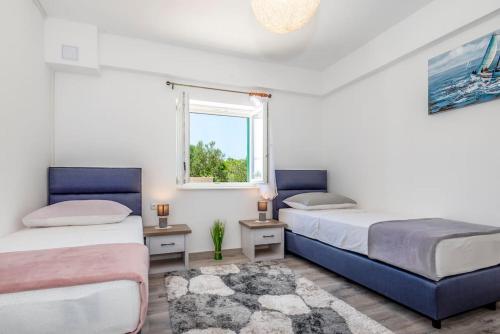 a bedroom with two beds and a window at APARTMENT AMELIA VRPOLJE in Vrpolje
