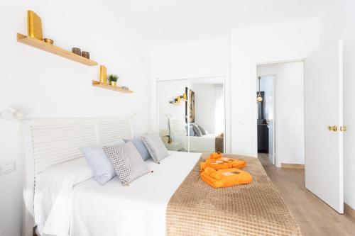 una camera da letto bianca con un letto bianco con cuscini arancioni di Sunrise in Paradise ad Adeje