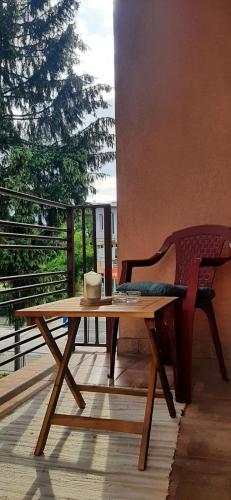 a wooden table and a chair on a balcony at IKA-M in Bihać