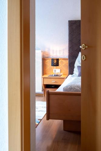 a bedroom with a bed and a desk with a lamp at Appartementhaus Bergland in Obsteig
