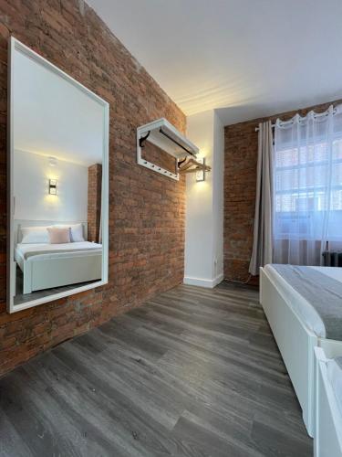a bedroom with a brick wall and a mirror at Hotel and the City, Empire State Building in New York