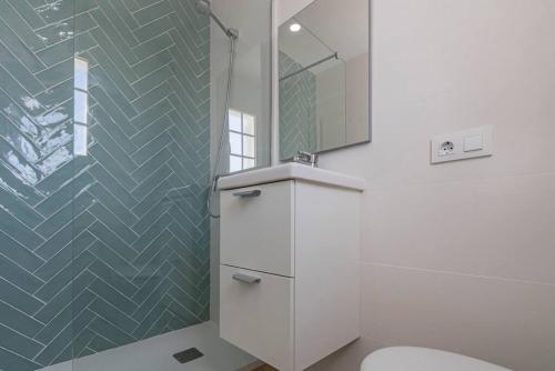 a bathroom with a white toilet and a mirror at Apartamento Castellsol 106 in Arenal d'en Castell