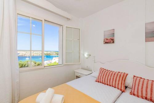 Un dormitorio blanco con una cama y una ventana grande. en Apartamento Castellsol 106, en Arenal d'en Castell