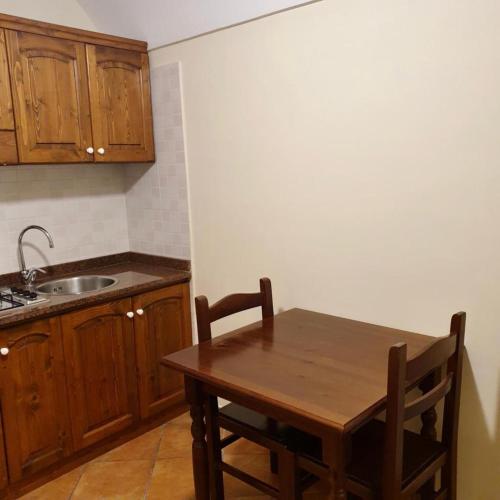 a kitchen with a wooden table and a sink at Residence l'Incanto in Piano di Sorrento