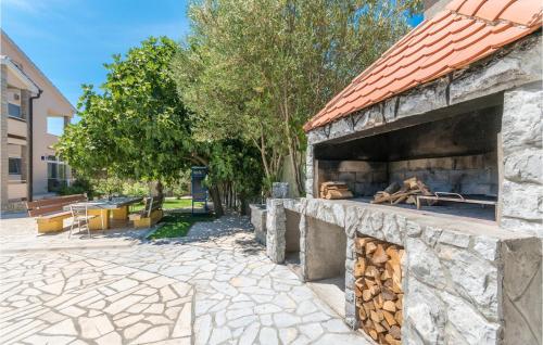 a stone building with a fireplace with a pile of wood at Holiday Home Zadar 37 in Kakma