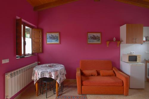 a room with a table and a chair and a kitchen at Apartamentos El Campal in Felechosa