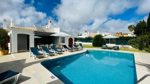 a swimming pool with lounge chairs and a house at Strip - Private Pool - 12 Guests - Albufeira in Albufeira