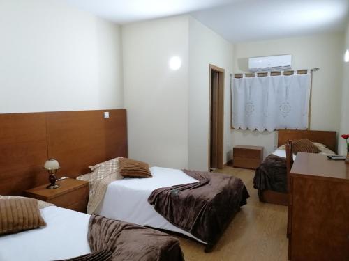 RibeirãoにあるColina do Ave Alojamento Localのベッドが2つと窓があるホテルの部屋