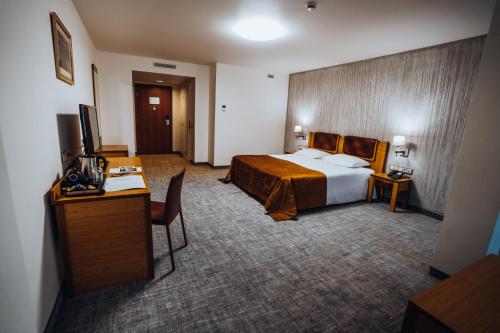 a hotel room with a bed and a desk at Gabija Hotel SPA & Conferences in Palanga