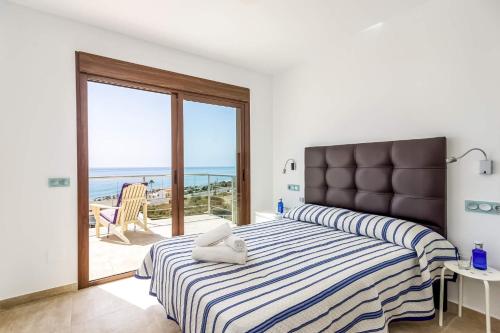 a bedroom with a bed with a view of the ocean at Villa Claraboya Sea View by Villa Plus in Torrox Costa