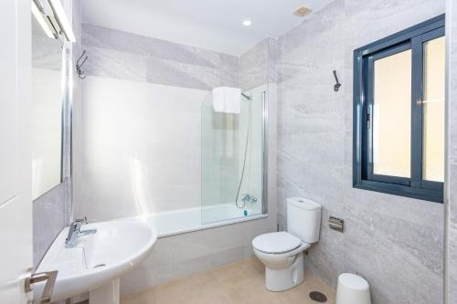 biała łazienka z toaletą i umywalką w obiekcie Villa Ladera Sol by Villa Plus w mieście Nerja