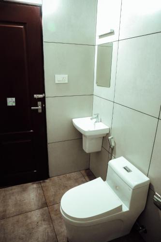 a bathroom with a toilet and a sink at Back Packers Cochin Villa in Cochin