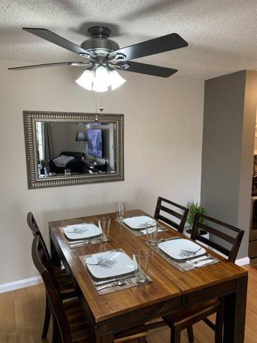 a dining room table with a ceiling fan and a mirror at Chris Cozy Condo Commonwealth #205 Edmonton in Edmonton