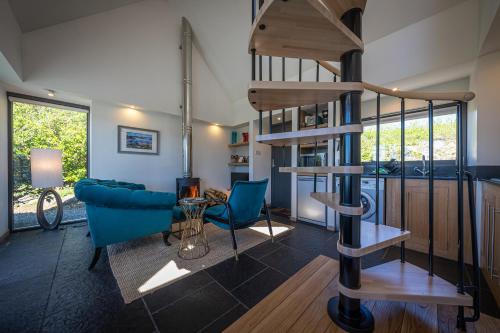 a living room with a spiral staircase in a house at The Byre in Stein