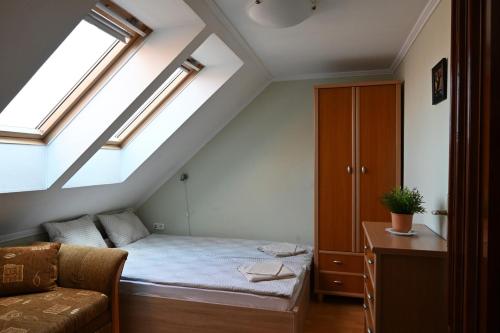 ジュラにあるLiszkai Apartmanの小さなベッドルーム(ベッド1台付)が備わる屋根裏部屋です。