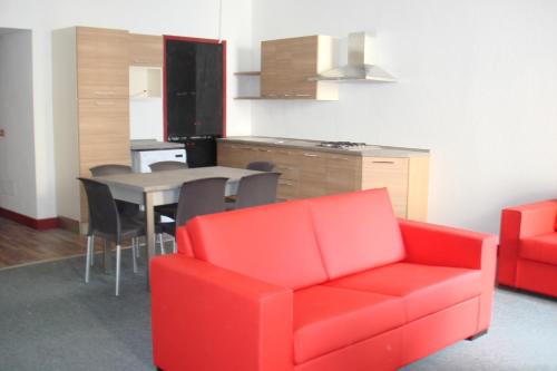 sala de estar con sofá rojo y mesa en Apartments Cabianchi, en Orta San Giulio