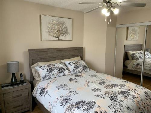 a bedroom with a large bed and a mirror at Chris Cozy Condo Commonwealth #205 Edmonton in Edmonton