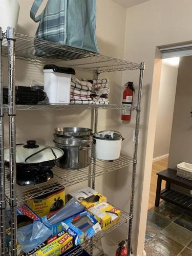 a kitchen shelving unit with food and other kitchen items at Chris Cozy Condo Commonwealth #205 Edmonton in Edmonton