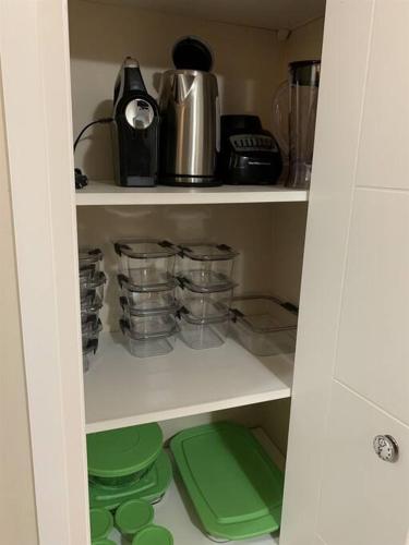 a kitchen pantry with green dishes and a coffee maker at Chris Cozy Condo Commonwealth #205 Edmonton in Edmonton