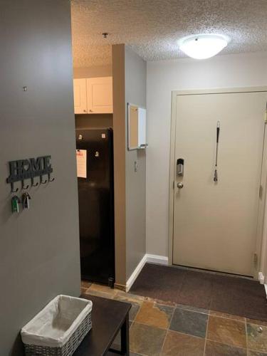 a room with a door and a table and a room with a refrigerator at Chris Cozy Condo Commonwealth #205 Edmonton in Edmonton