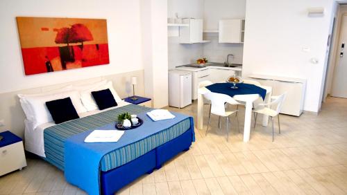 萊烏卡的住宿－La Corte di Leuca Residence & SPA，一间卧室配有一张床铺和一张桌子,还设有一间厨房