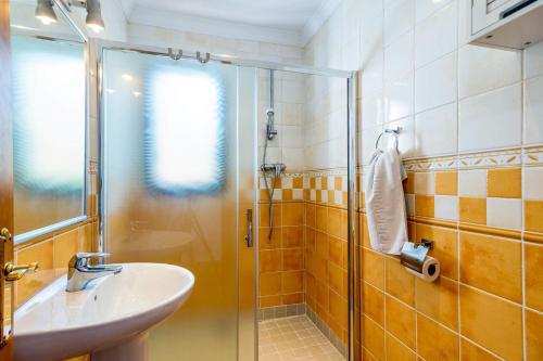 een badkamer met een wastafel en een glazen douche bij Villa Tres Olivos by Villa Plus in Frigiliana