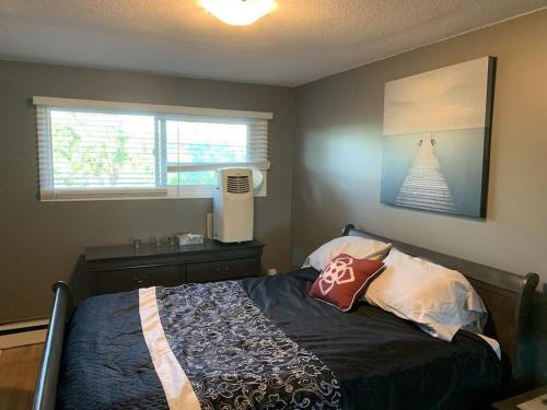 a small bedroom with a bed and a window at Chris Cozy Condo Lebay Regina in Regina