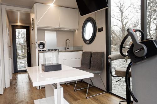 une petite cuisine avec une table blanche et une fenêtre dans l'établissement Apartament na wodzie - Riveraparts - Marina Oława, à Oława