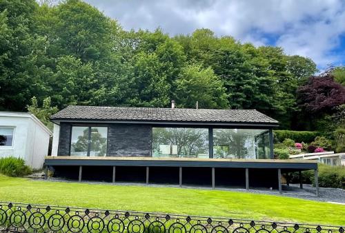 a house with a glass extension in a yard at The Lookout in Tighnabruaich
