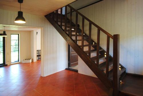 a wooden staircase in a room with a tile floor at Dzūkijos uoga in Viršurodukis