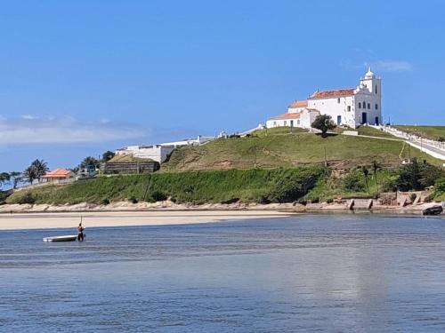 una persona in piedi in acqua di fronte a un castello di Pousada das Casuarinas a Saquarema