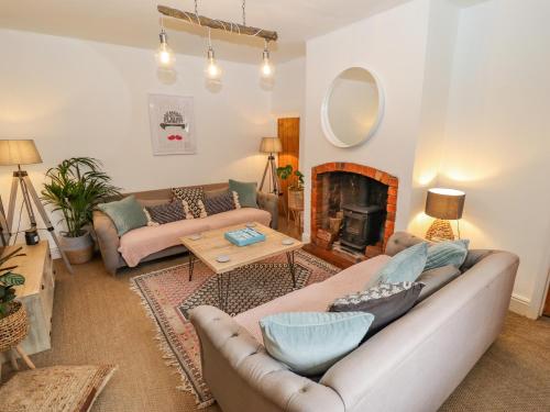 a living room with two couches and a fireplace at Old Rectory Cottage in Lincoln