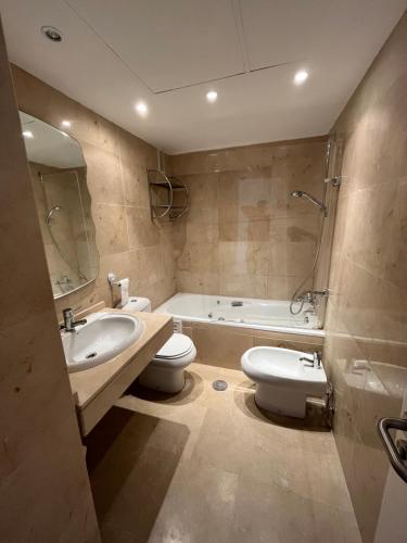 a bathroom with a sink and a toilet and a tub at Puerto de la Duquesa MINIMUM 3 NUITS in Manilva