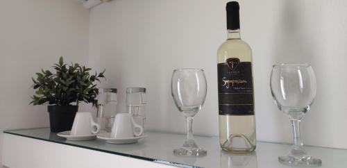 a bottle of wine sitting on a table with two wine glasses at Sea Harmony in Kalathos