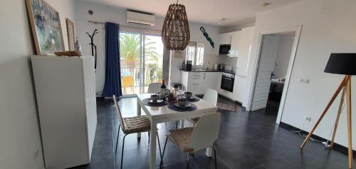 kuchnia i jadalnia ze stołem i krzesłami w obiekcie AP339 Alhama-La Oliva w mieście Nerja