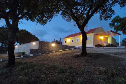 a house at night with trees in the foreground at Celestial Melides Country House in Melides